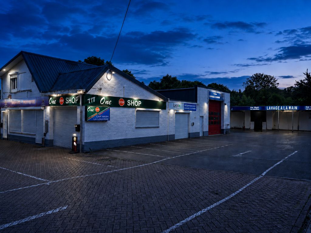 La devanture du car wash de nuit, enseignes allumées, rue Gustave Boël
